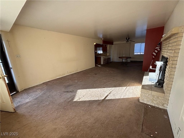 unfurnished living room with carpet floors, a fireplace, and ceiling fan