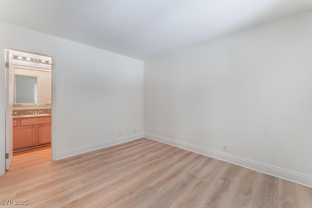 spare room with sink and light wood-type flooring