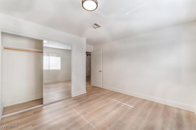 unfurnished bedroom with light hardwood / wood-style flooring and a closet