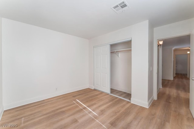 unfurnished bedroom featuring light hardwood / wood-style floors and a closet