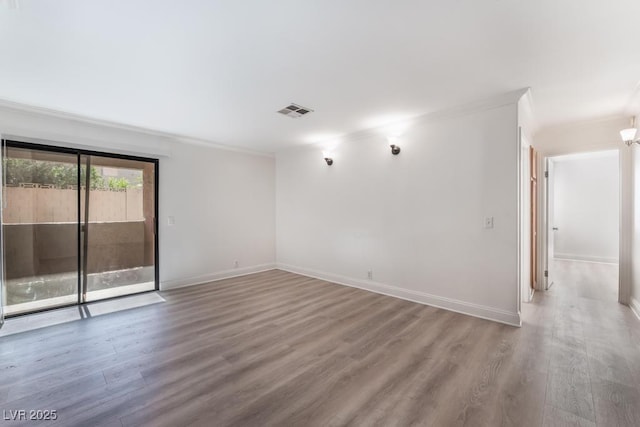 empty room featuring hardwood / wood-style floors and ornamental molding