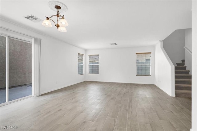 unfurnished living room featuring light hardwood / wood-style floors and a notable chandelier