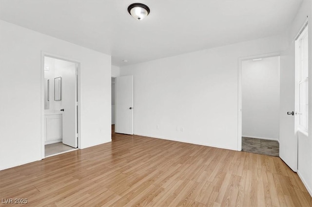 unfurnished bedroom with connected bathroom and light hardwood / wood-style floors