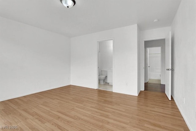 unfurnished bedroom with ensuite bath and light hardwood / wood-style flooring