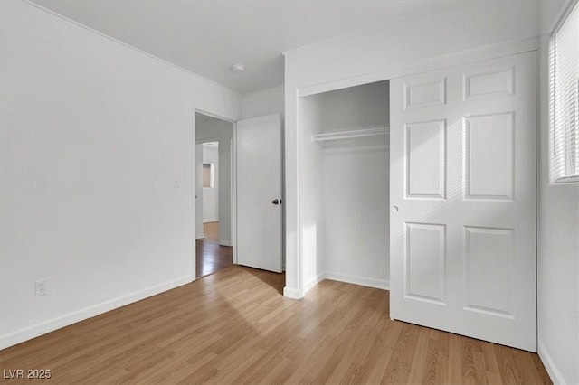 unfurnished bedroom featuring light hardwood / wood-style flooring and a closet