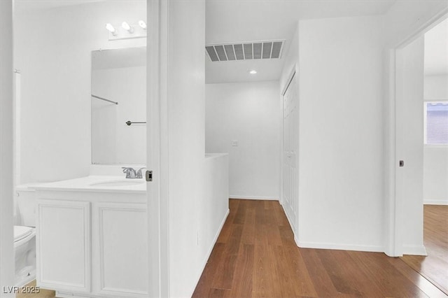 bathroom with hardwood / wood-style flooring, vanity, and toilet