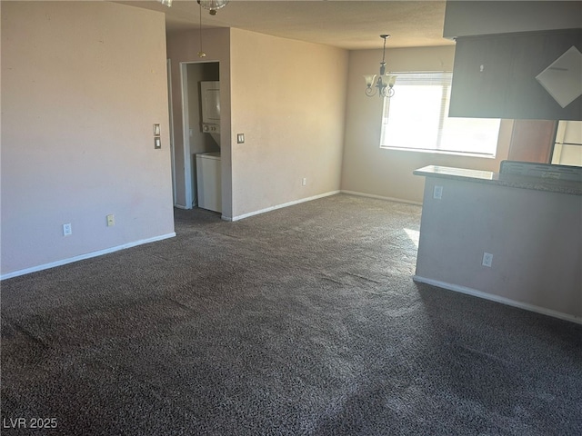 empty room with a chandelier and dark carpet