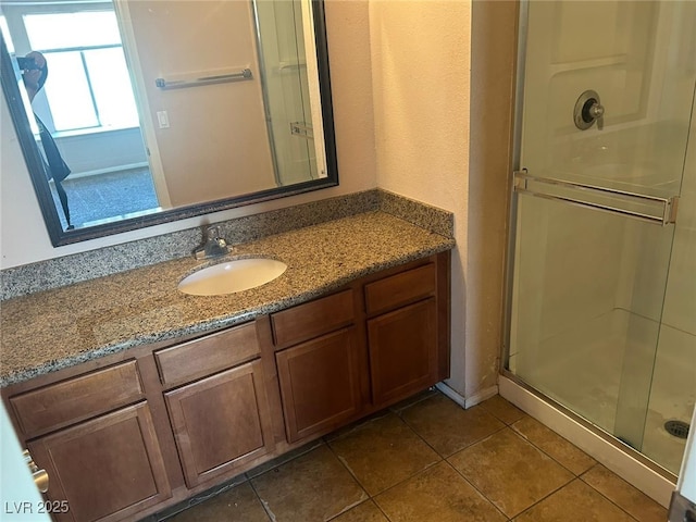 bathroom featuring vanity, tile patterned flooring, and a shower with door