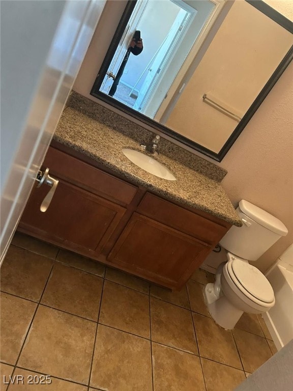 bathroom with tile patterned flooring, vanity, and toilet