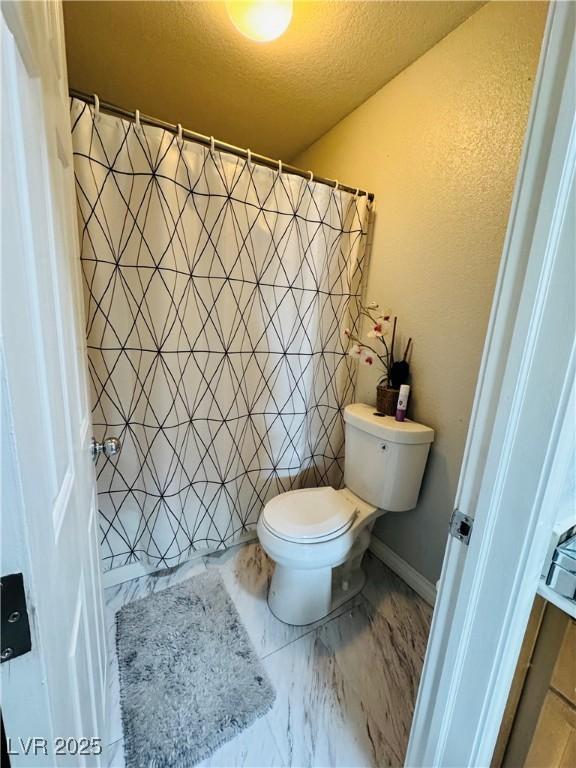 bathroom featuring a textured ceiling and toilet