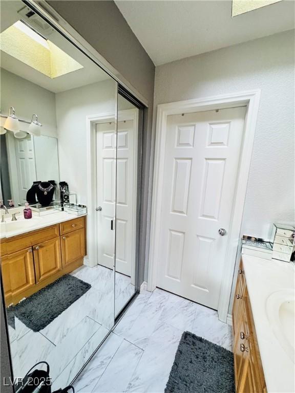 bathroom featuring vanity and a skylight