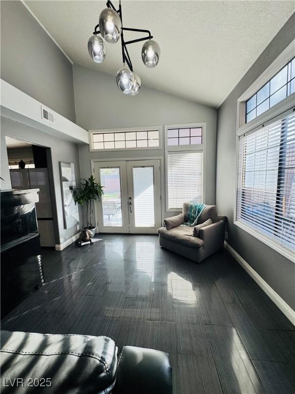 living room with dark hardwood / wood-style floors, lofted ceiling, french doors, and a textured ceiling