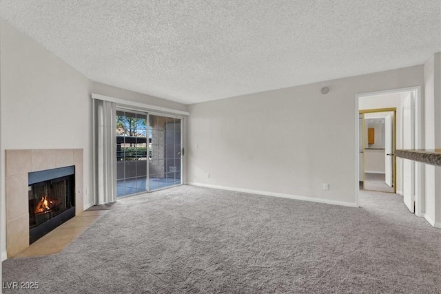 unfurnished living room with a tiled fireplace, light carpet, and a textured ceiling