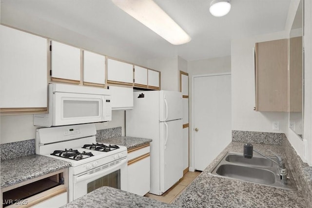 kitchen with white cabinetry, sink, white appliances, and light tile patterned floors