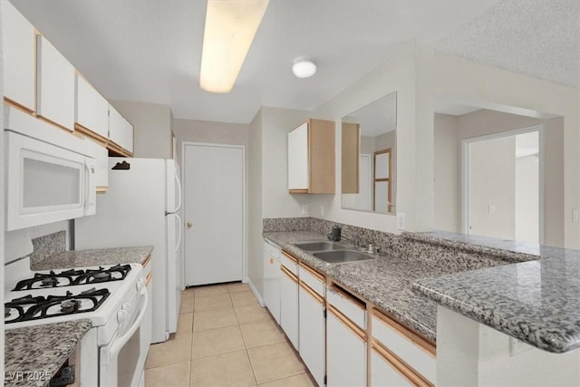 kitchen featuring sink, light tile patterned floors, stone counters, white appliances, and white cabinets