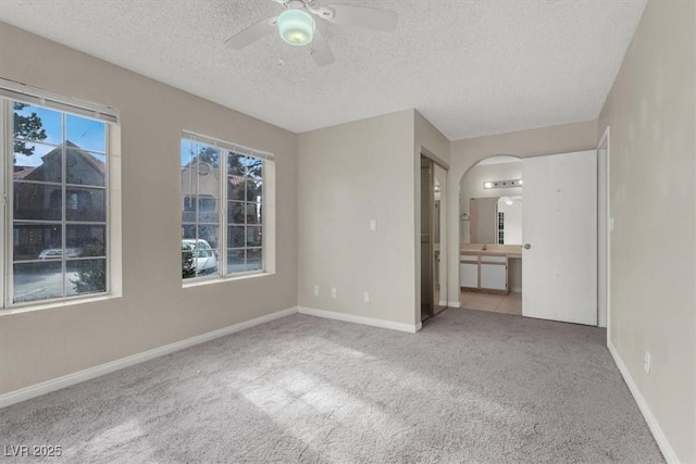 carpeted spare room with ceiling fan and a textured ceiling