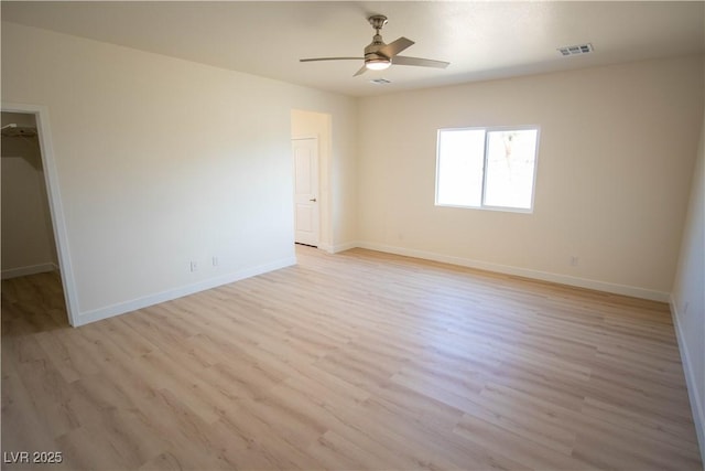 unfurnished room with baseboards, a ceiling fan, and light wood-style floors