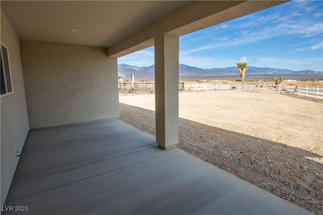 view of patio featuring fence and a mountain view