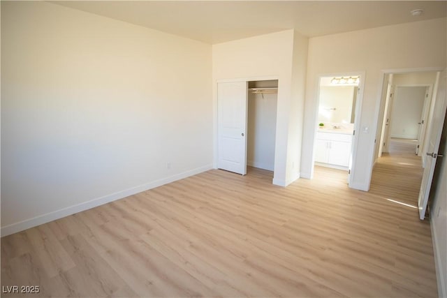 unfurnished bedroom with baseboards, a closet, and light wood-style floors