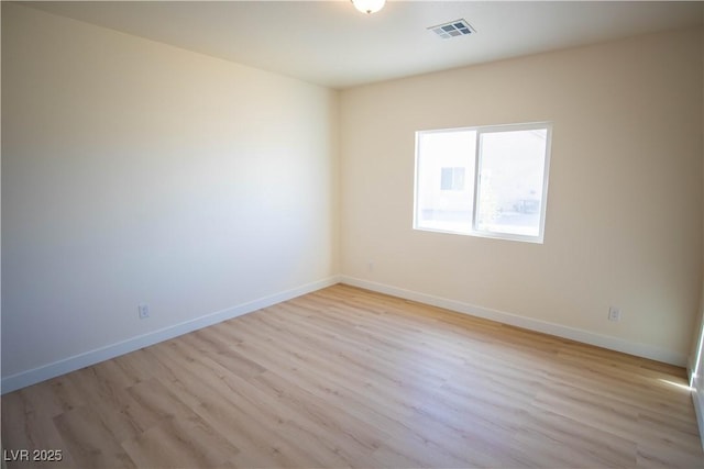 unfurnished room with light wood-style flooring, visible vents, and baseboards