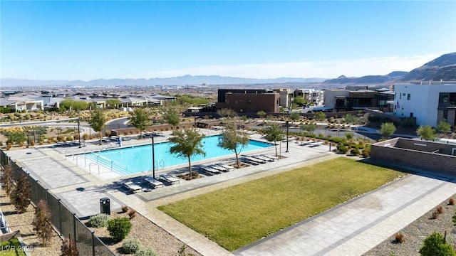 view of swimming pool with a mountain view, a lawn, and a patio area