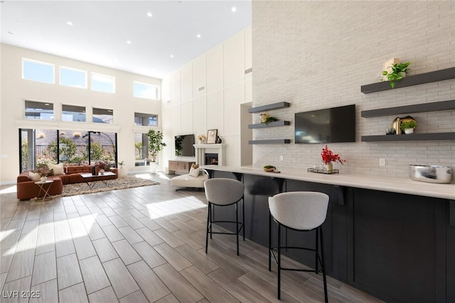 kitchen featuring white cabinetry, a towering ceiling, and a kitchen bar