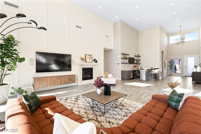 living room with light hardwood / wood-style floors and a high ceiling