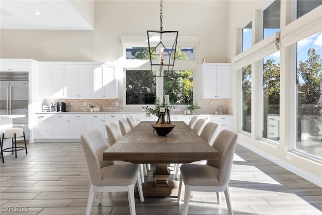 dining area featuring an inviting chandelier and a high ceiling