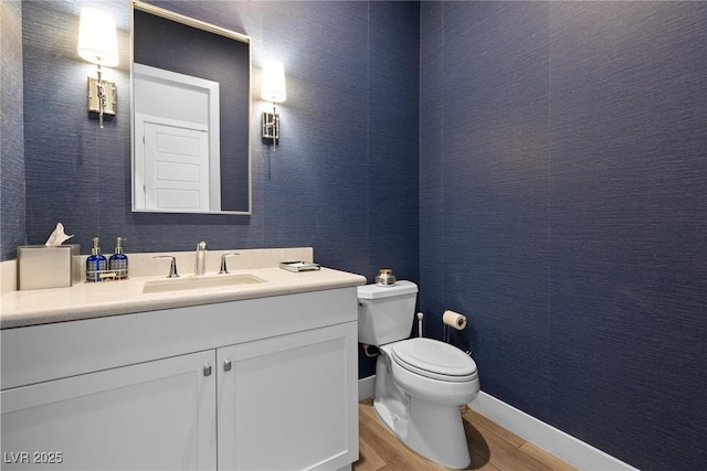 bathroom featuring vanity, hardwood / wood-style floors, and toilet