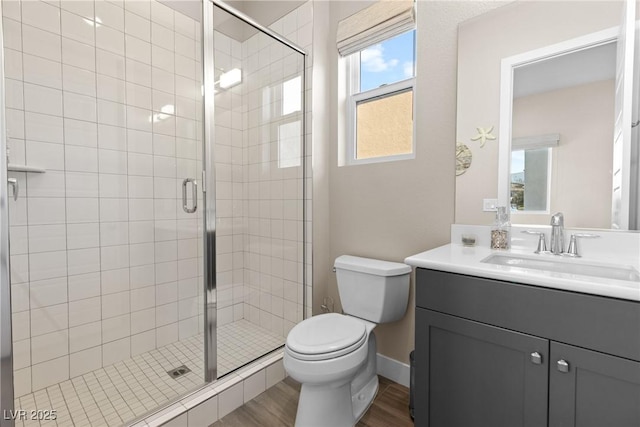 bathroom with hardwood / wood-style flooring, vanity, an enclosed shower, and toilet