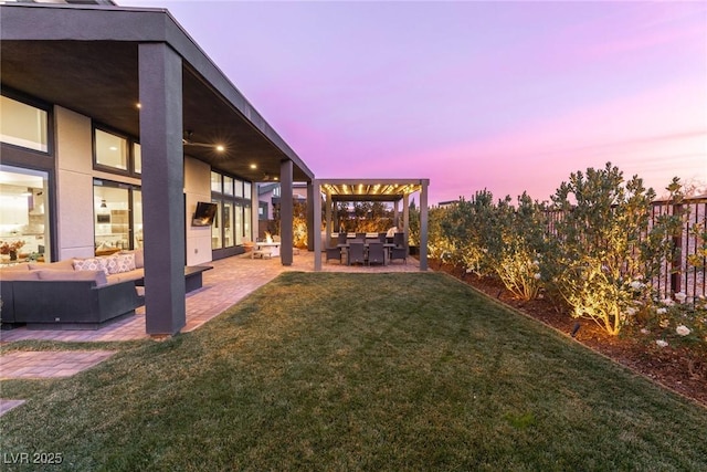 yard at dusk with outdoor lounge area and a patio