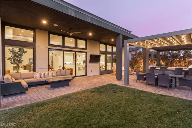 rear view of house with outdoor lounge area, a patio, and a lawn