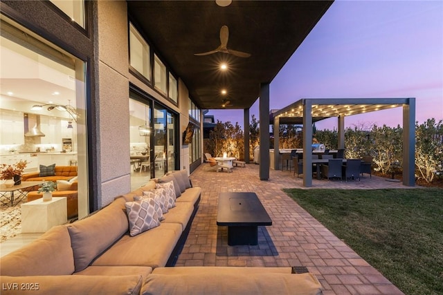 patio terrace at dusk with an outdoor living space with a fire pit and ceiling fan