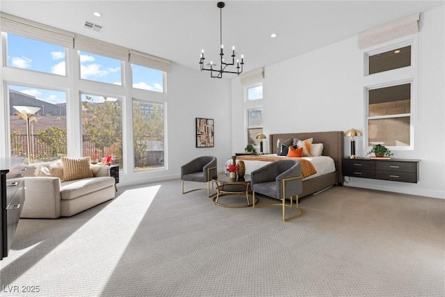 bedroom featuring light carpet, a towering ceiling, multiple windows, and a chandelier