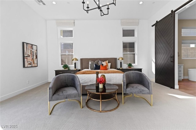 sitting room featuring an inviting chandelier, a barn door, and light carpet