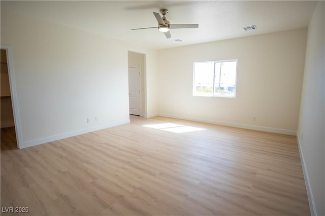 unfurnished room featuring light wood-type flooring, baseboards, visible vents, and a ceiling fan