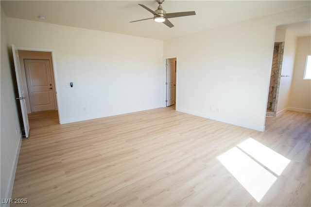 spare room featuring baseboards, light wood-style floors, and a ceiling fan