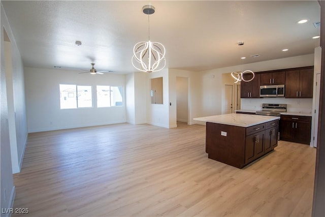 kitchen featuring pendant lighting, light wood finished floors, and stainless steel appliances