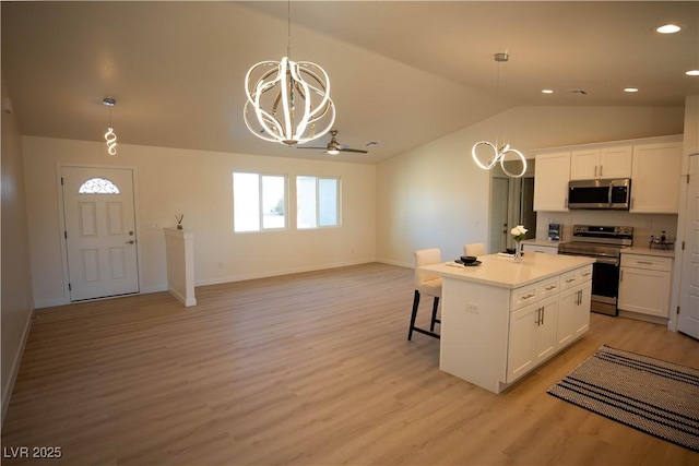 kitchen featuring light countertops, appliances with stainless steel finishes, open floor plan, white cabinets, and a kitchen island