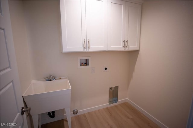 clothes washing area with hookup for a washing machine, cabinet space, electric dryer hookup, light wood-type flooring, and baseboards