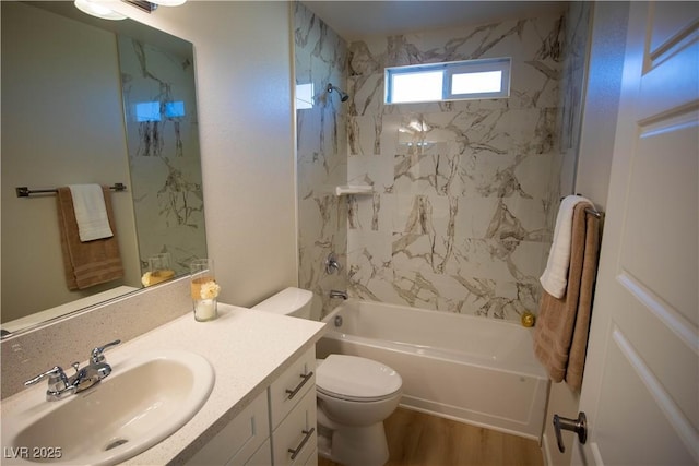 bathroom featuring wood finished floors, shower / bath combination, vanity, and toilet