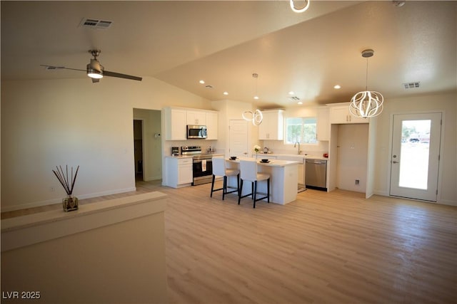 kitchen featuring a center island, light countertops, visible vents, appliances with stainless steel finishes, and white cabinetry