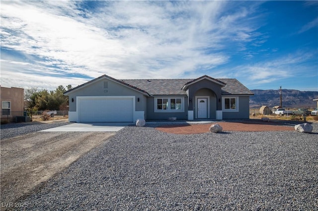 ranch-style home featuring central air condition unit, stucco siding, driveway, a garage, and a tiled roof