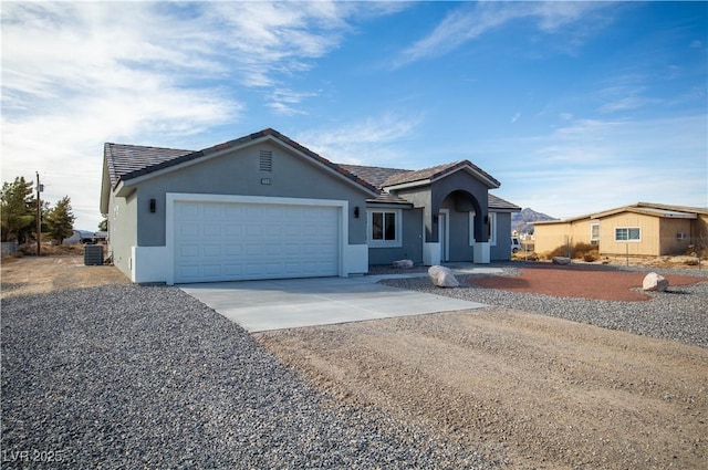 ranch-style house with stucco siding, concrete driveway, an attached garage, and a tile roof