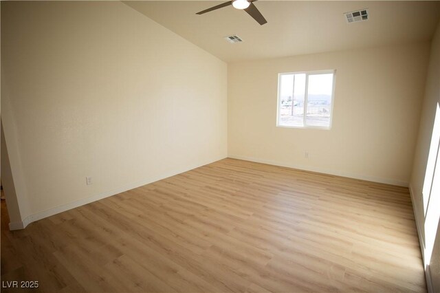 spare room with light wood-type flooring, visible vents, and ceiling fan