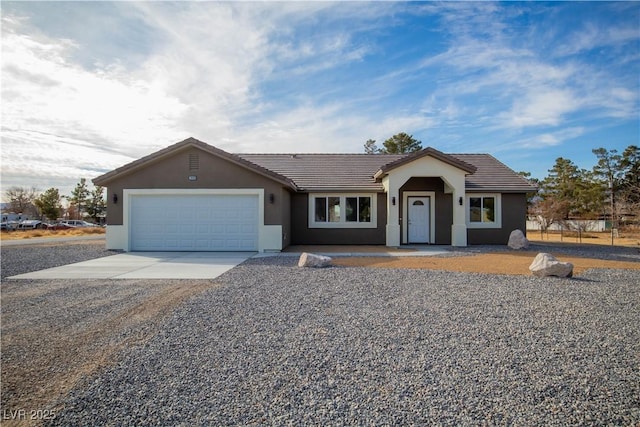 ranch-style home featuring stucco siding, a tiled roof, concrete driveway, and a garage