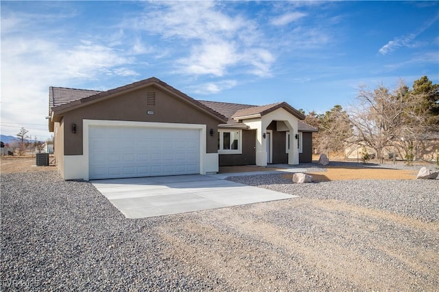 ranch-style home with stucco siding, driveway, a tile roof, and an attached garage