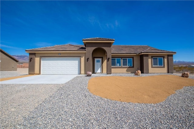 5821 Genoa Ave, Pahrump, NV 89060 - prairie-style home featuring a garage, a tile roof, concrete driveway, and stucco siding