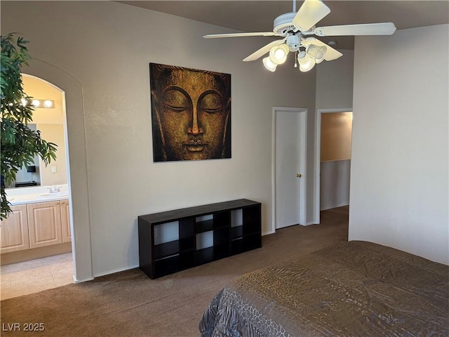 bedroom featuring light carpet, sink, ensuite bath, and ceiling fan