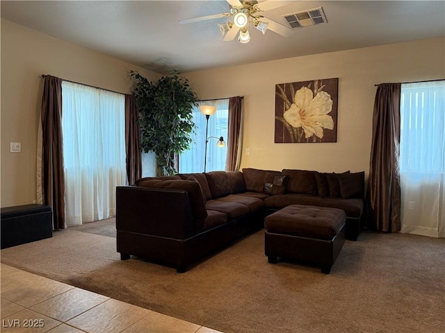 living room featuring ceiling fan, light colored carpet, and a wealth of natural light